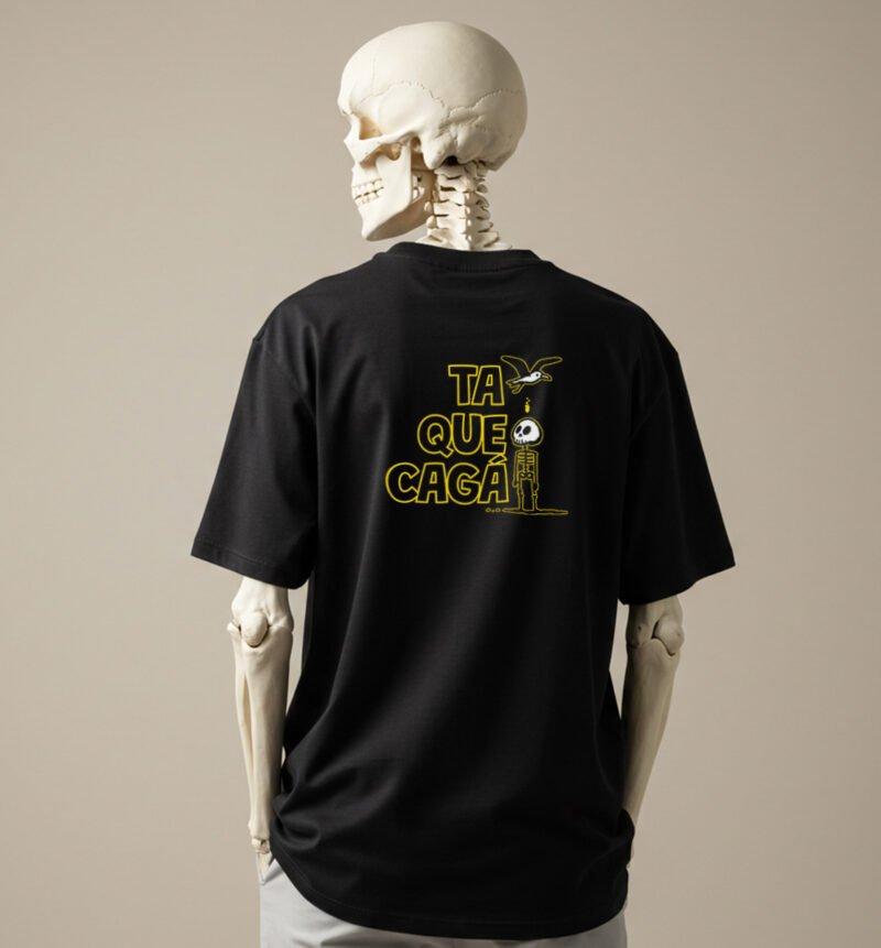 La imagen muestra a un esqueleto luciendo la parte trasera del diseño Cagao, de la línea de polos clásicos perteneciente a la Colección Calacas.