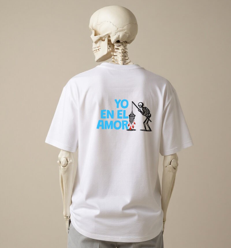 La imagen muestra a un esqueleto luciendo la parte trasera del diseño Enamorao, de la línea de polos clásicos perteneciente a la Colección Calacas, en versión blanca.